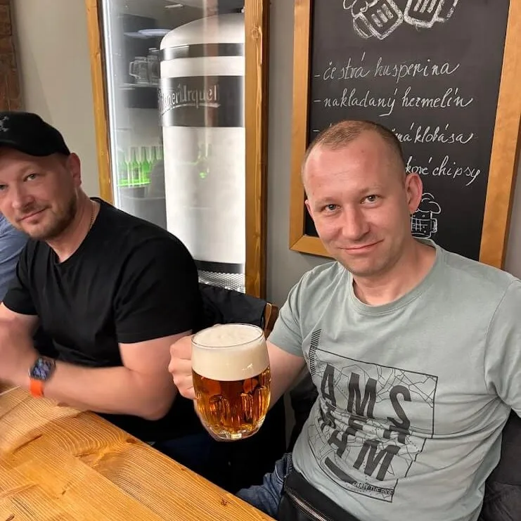 Dos hombres disfrutando de una cata de cerveza artesanal en un pub de Bratislava