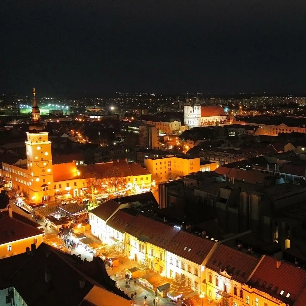 Vista aérea nocturna del iluminado centro histórico de Trnava con sus iglesias