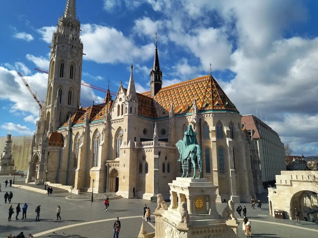 La iglesia de Matías de Budapest con su tejado de azulejos de colores y la estatua ecuestre de san Esteban ante el Bastión de los Pescadores.