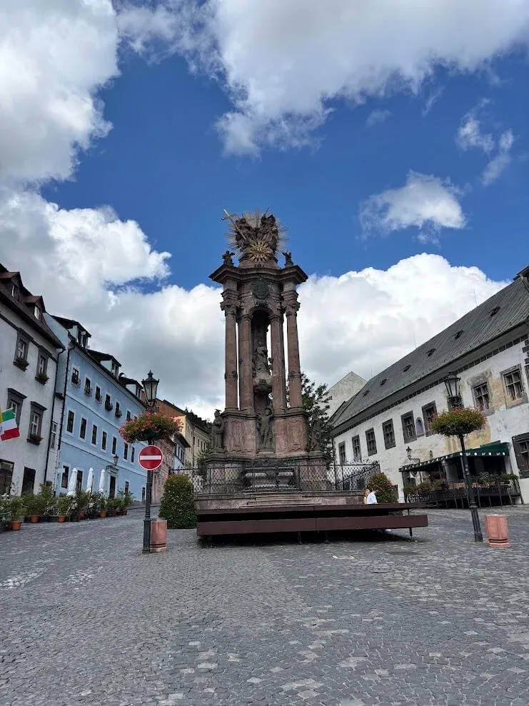 The baroque Holy Trinity plague column standing on the cobbled Trinity Square in Banská Štiavnica, ringed by painted burgher houses.