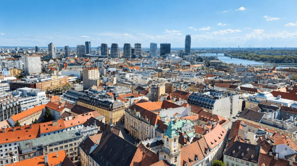 Bratislava from above: the red roofs of the old town giving way to the towers of the business district and the Danube beyond.
