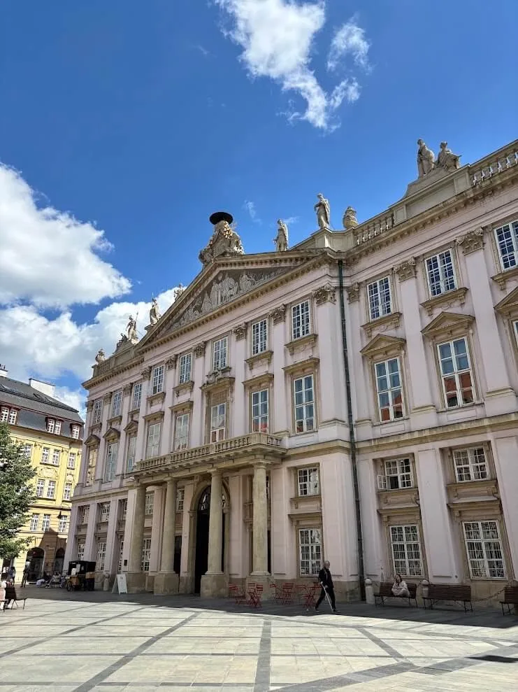 The Primate's Palace in Bratislava, its pink neoclassical facade topped with statues.