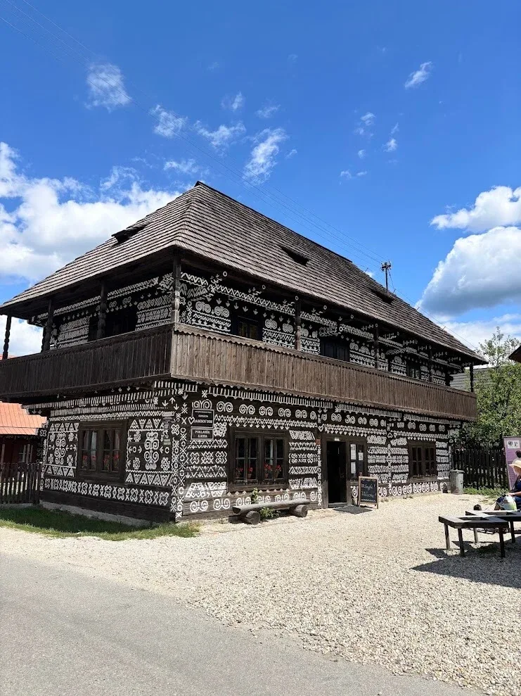 Radenov dom in Čičmany, a two-storey semi-detached log house covered in the white geometric patterns the village is known for.