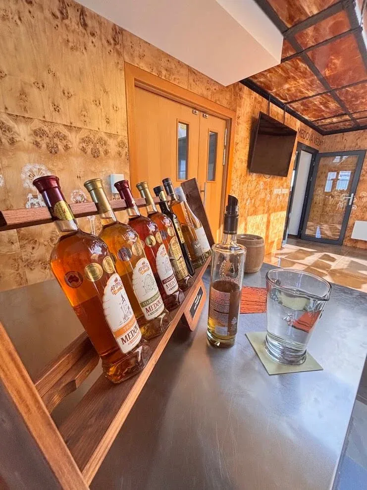 Bottles of Slovak mead lined up on a wooden tasting shelf at a mead producer at Dolná Krupá near Trnava.