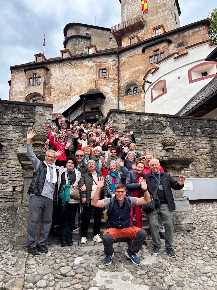 Andrej Stanik con un grande gruppo di turisti festante sui gradini del castello di Orava.