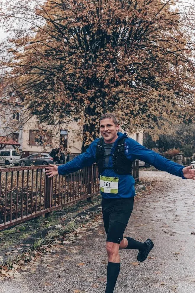Andrej Stanik che corre in una gara autunnale, a braccia spalancate mentre passa davanti alla fotocamera.