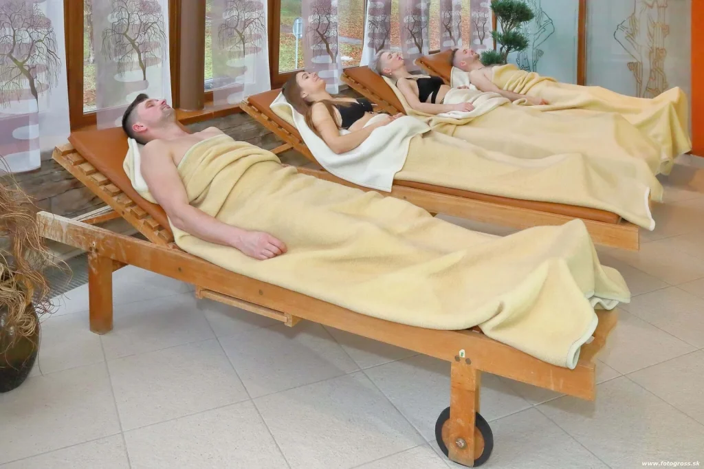 Guests resting on wooden loungers under wool blankets in a relaxation room at the Bojnice spa. Photo: www.fotogross.sk.