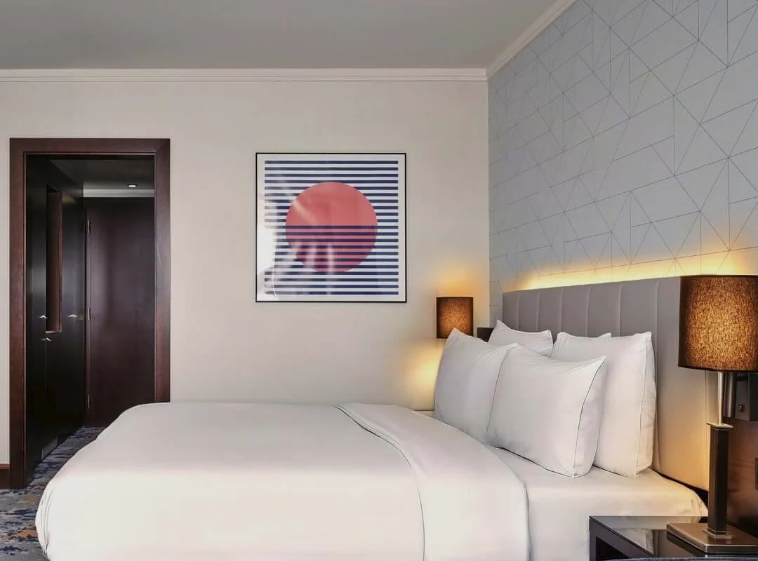 Una camera per gli ospiti del Crowne Plaza Bratislava, con un letto matrimoniale e una stampa d’arte moderna alla parete.