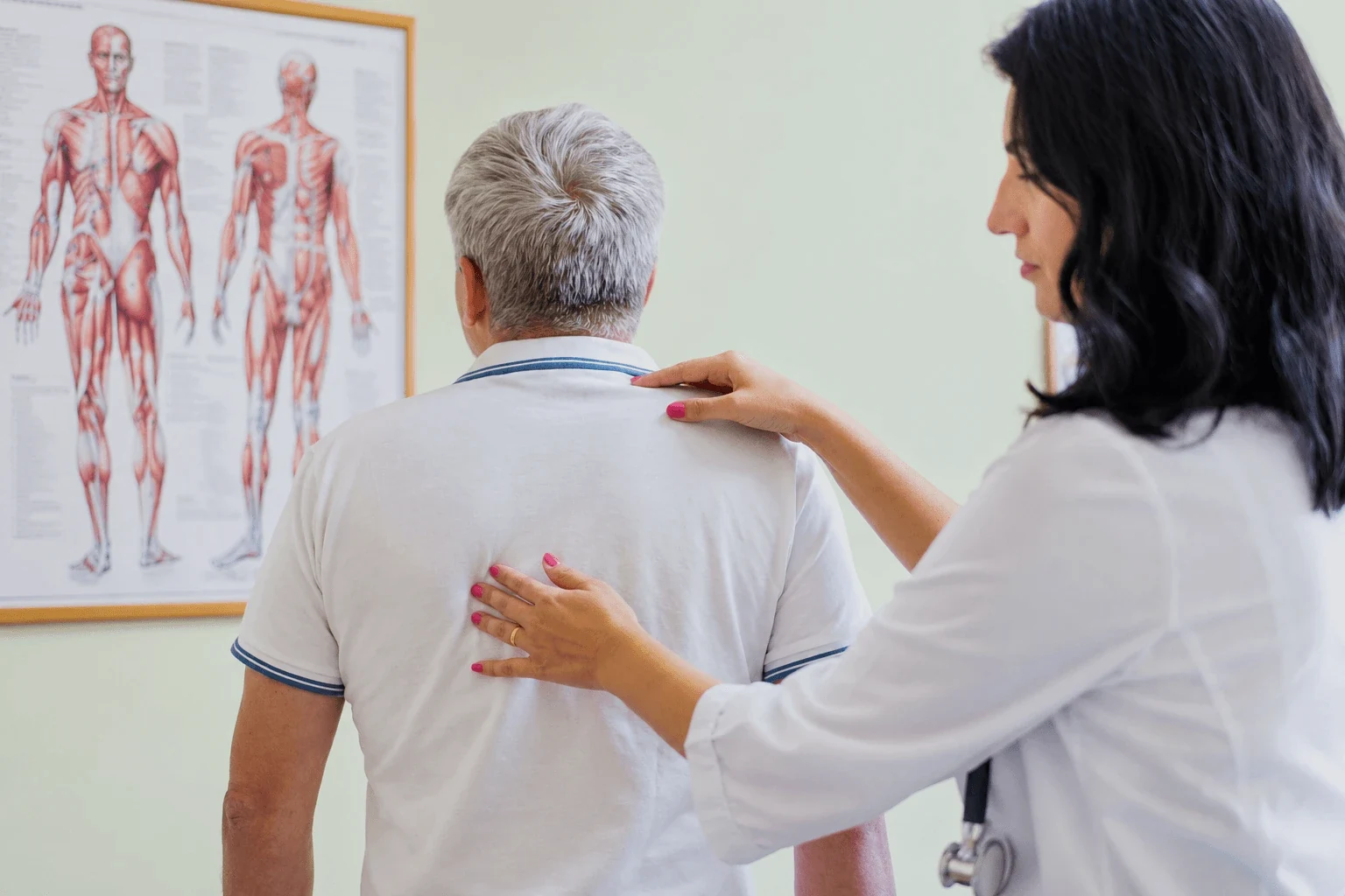 A doctor examining a patient's back and spine during a consultation at the spa in Dudince.