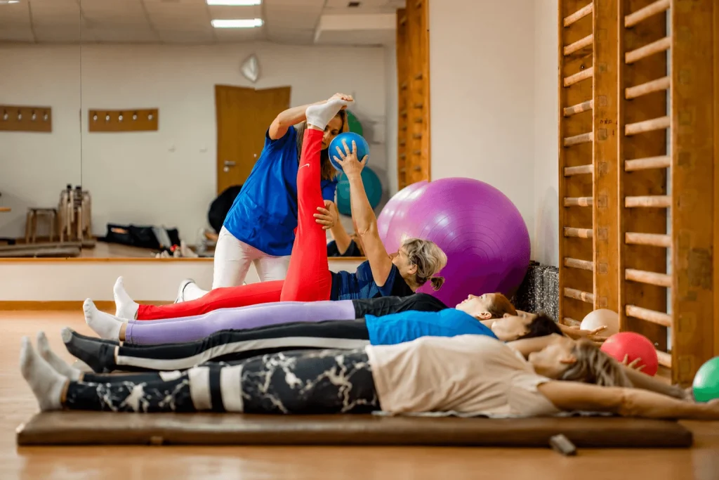 A physiotherapist leading a group exercise class on mats in the gym at the spa in Dudince.