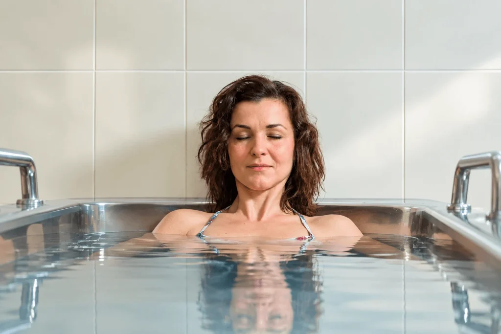 A guest relaxing in a mineral bath in a tiled treatment room at the spa in Dudince.