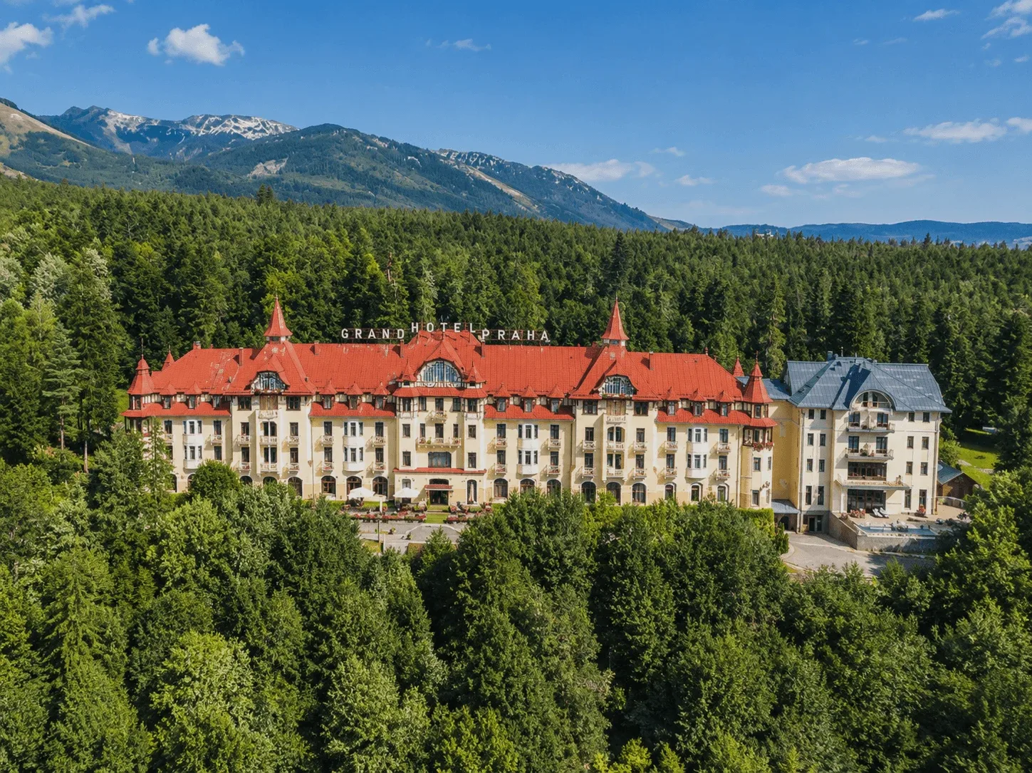 Il Grand Hotel Praha a Tatranská Lomnica, circondato dalla foresta sotto le cime degli Alti Tatra.