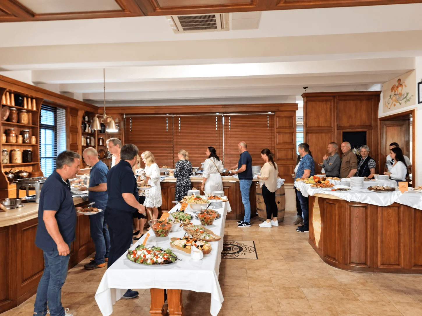 Un groupe se servant à un buffet pour le déjeuner dans un restaurant lambrissé de bois à Bratislava.