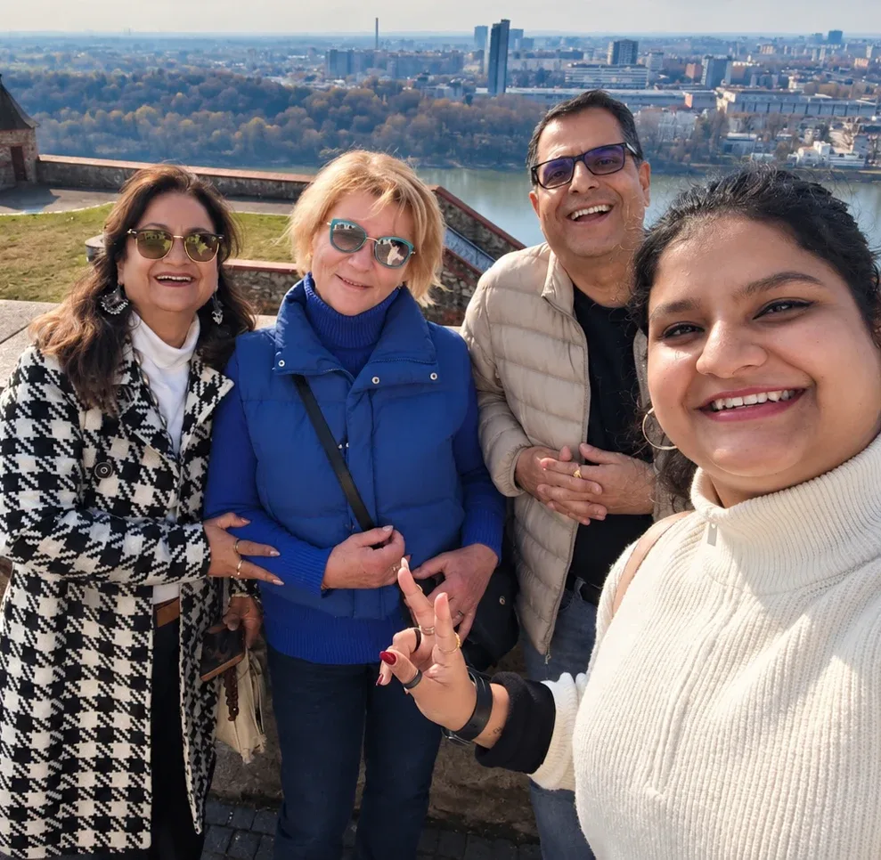 Un guía local con un pequeño grupo de huéspedes en la terraza del Castillo de Bratislava, con el Danubio y Petržalka al fondo.