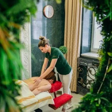 A therapist giving a guest a back massage in a treatment room at the Aphrodite spa in Rajecké Teplice.