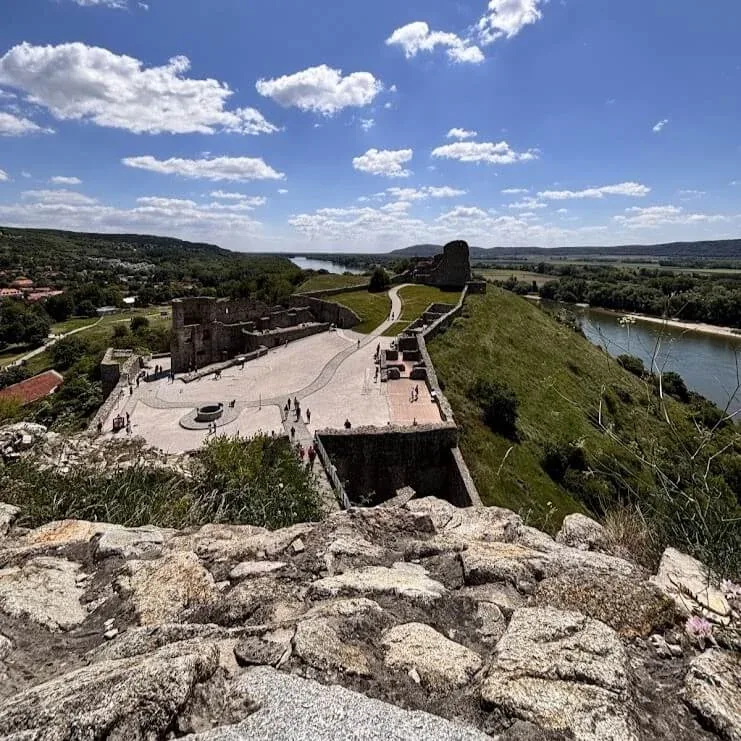 The stone ruins of a castle on a hill, with the river valley below.