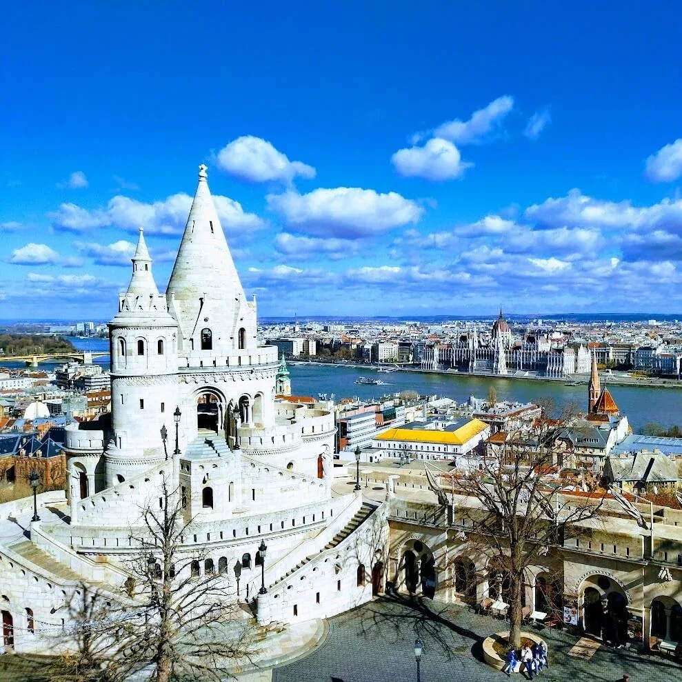 The white turrets and arcades of the Fisherman's Bastion on Castle Hill in Budapest, with the Danube and the rooftops of Pest below.