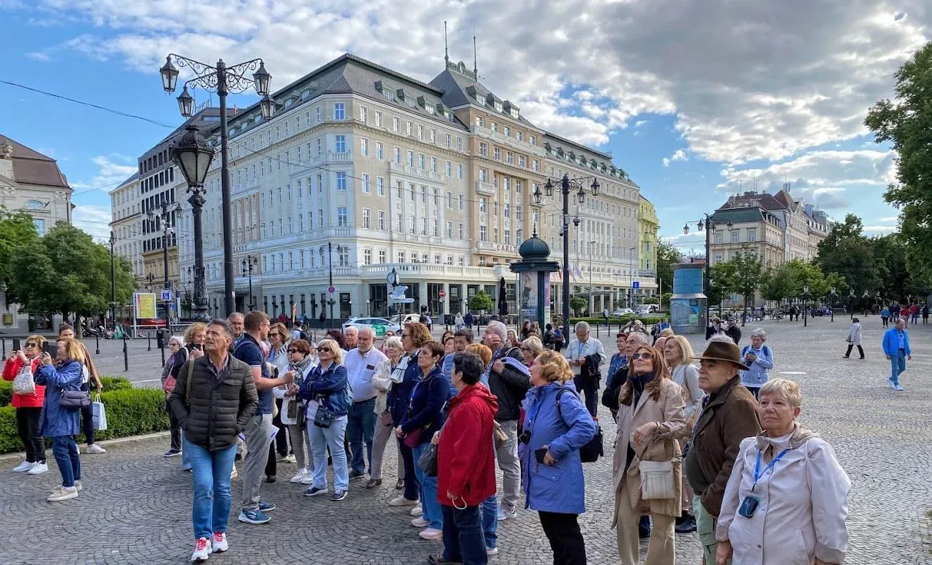 Un groupe de touristes sur la place Hviezdoslav, dans la vieille ville de Bratislava, rassemblé devant l'historique hôtel Carlton.
