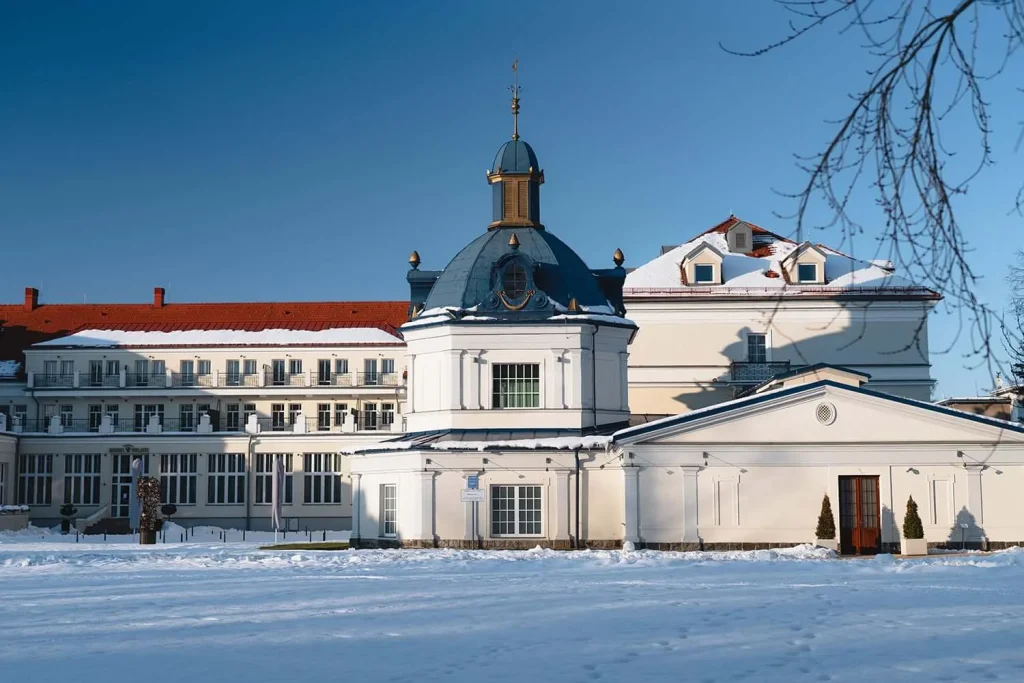 The Blue Bath (Modrý kúpeľ), the domed historic bathhouse in Turčianske Teplice, in winter snow with the spa hotel behind.