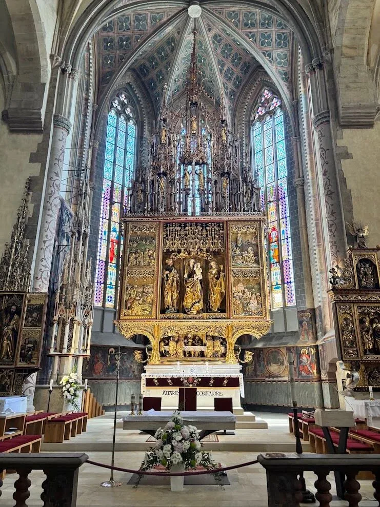 The gilded Gothic high altar carved by Master Pavol in St James's Church in Levoča, the tallest wooden altar in the world, beneath stained-glass windows.