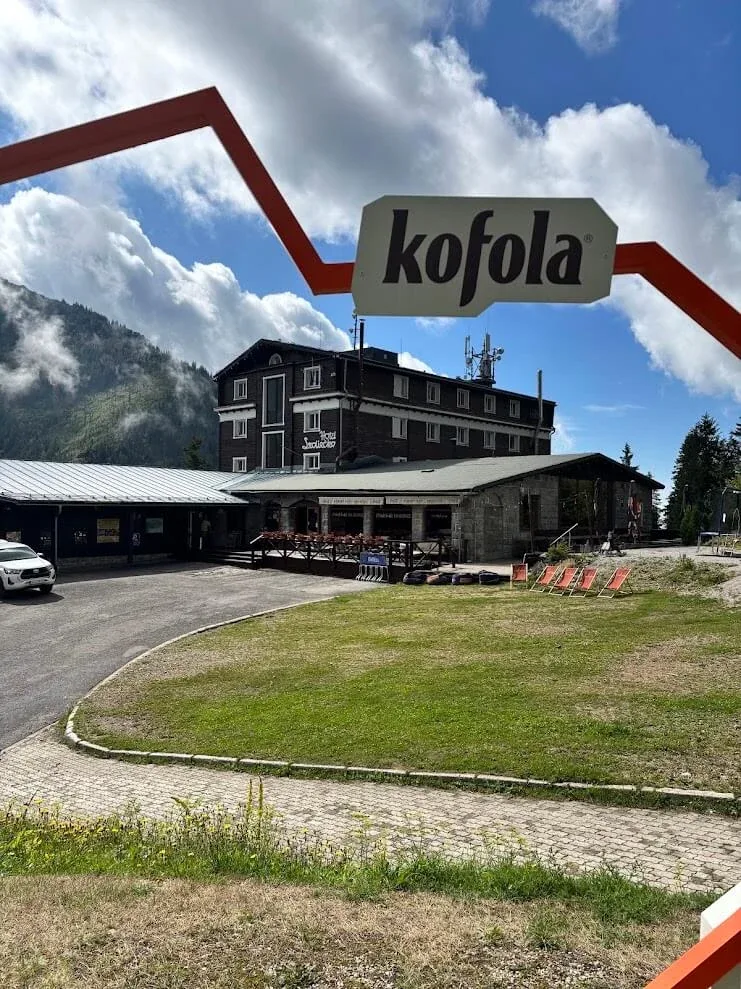 A mountain hotel and its terrace at a saddle in the Low Tatras, with deckchairs set out on the grass below.