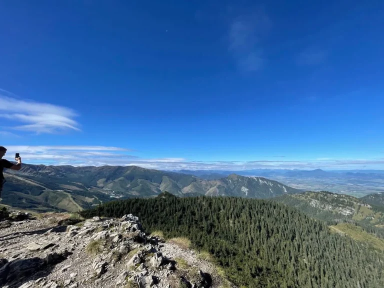 A summer panorama from a ridge in the Low Tatras, across forested ridges to the valley far below.