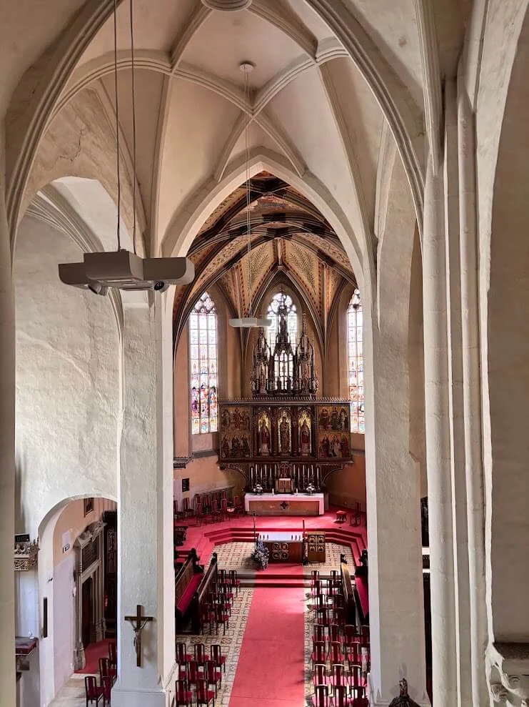 The Gothic interior of St Martin's Cathedral at Spišská Kapitula, its ribbed vault above a red carpet leading to the altar.