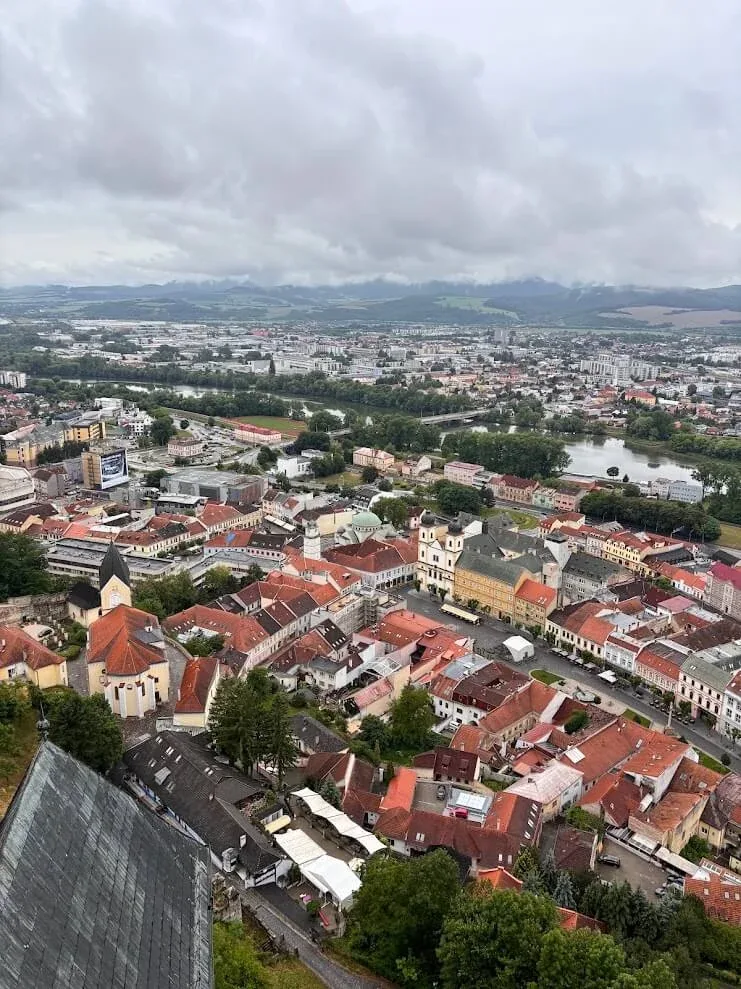 The view from Trenčín Castle over the red roofs of the old town and the Váh River, with the hills beyond.