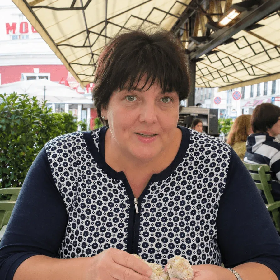 Gabriela, Mitgründerin von E-TRAVEL.SK, an einem Tisch auf einer Caféterrasse unter einer Markise.