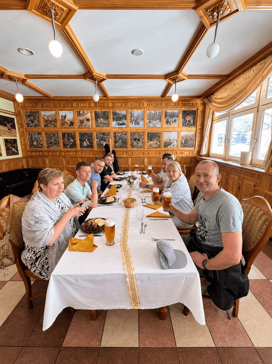 A tour group at a long table at the Diana restaurant in Stráža in northern Slovakia, raising glasses of beer over plates of game and dumplings, the wood-panelled walls hung with painted hunting scenes of deer, boar, fox and chamois.