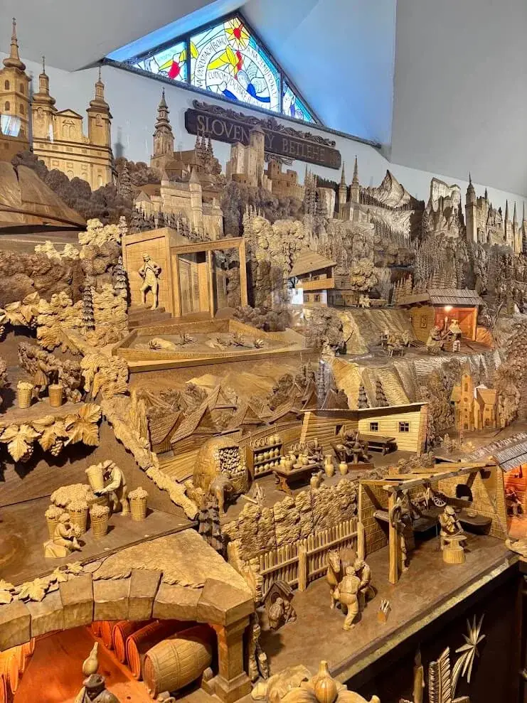 A detail of the Slovak Bethlehem at Rajecká Lesná, a carved wooden panorama of villages, churches and working figures.