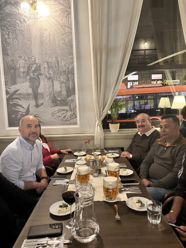 Delegates at the folk dinner in Café Štefánka, Bratislava, with the restaurant’s period murals behind them.