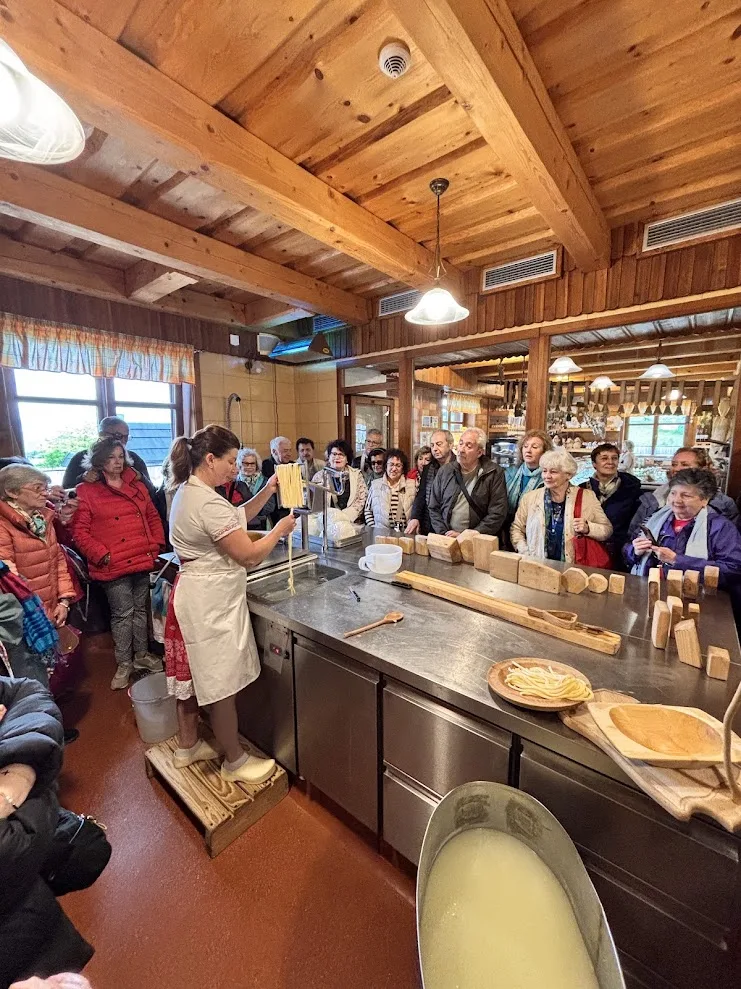 A dairywoman drawing out a strand of steamed sheep’s cheese for korbáčiky in front of a visiting group at the cheese workshop in Zázrivá near Žilina.