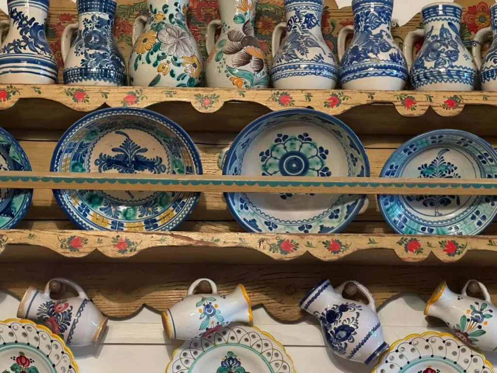 Shelves of traditional Slovak majolica — blue-and-white painted jugs, plates and pitchers — arranged on a painted wooden dresser in Pezinok.
