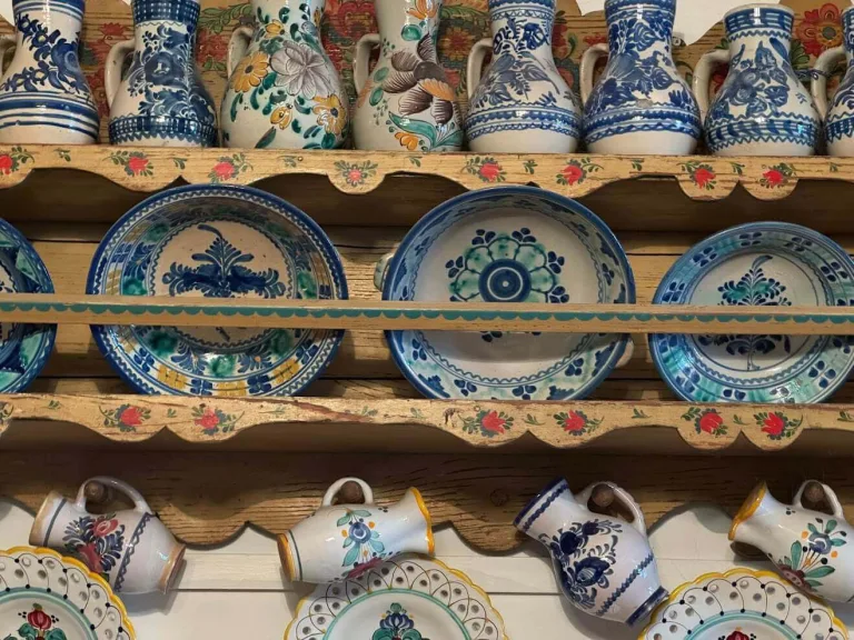 Shelves of traditional Slovak majolica — blue-and-white painted jugs, plates and pitchers — arranged on a painted wooden dresser in Pezinok.
