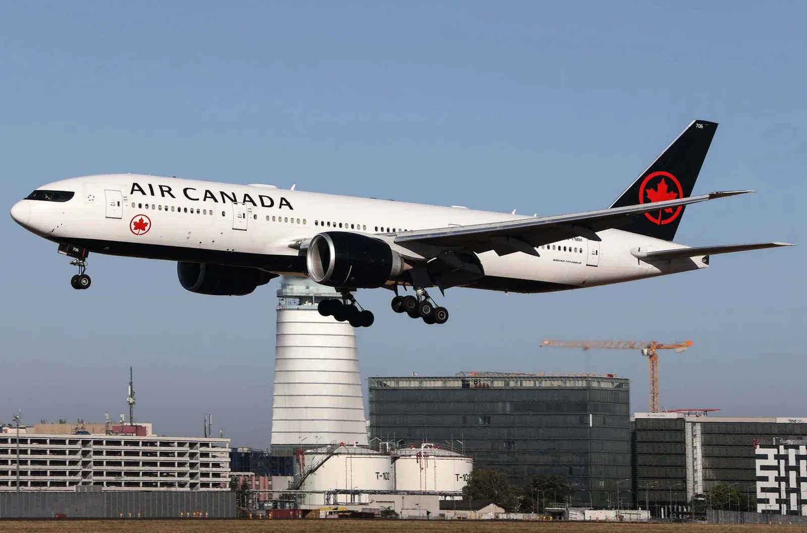 Eine Boeing 777 von Air Canada im Landeanflug auf den Flughafen Wien, vor dem Kontrollturm des Flughafens.