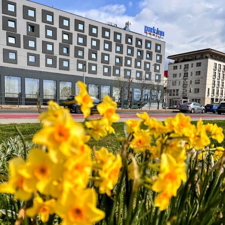 Spring flowers in front of Park Inn by Radisson Danube Hotel, a modern MICE venue in Bratislava near the Danube River, ideal for corporate events.