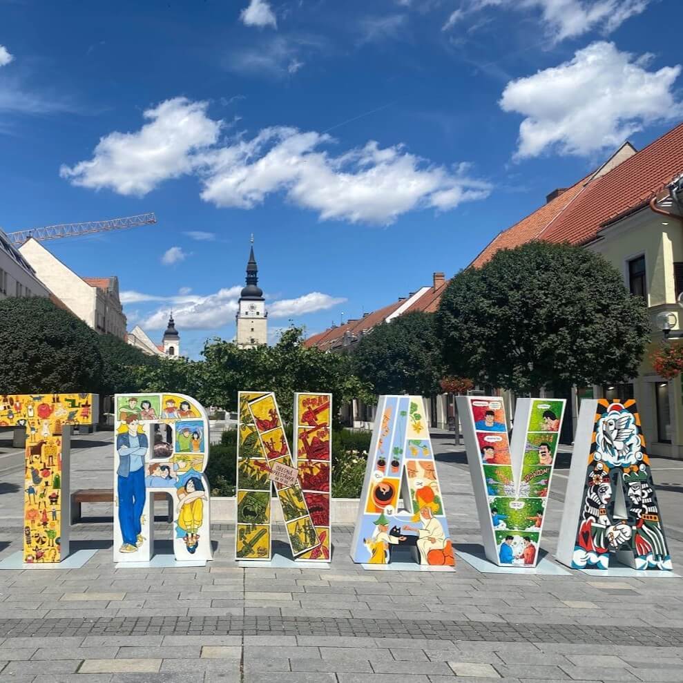 Colorful TRNAVA letters sign on Trinity Square with City Tower, Little Rome of Slovakia