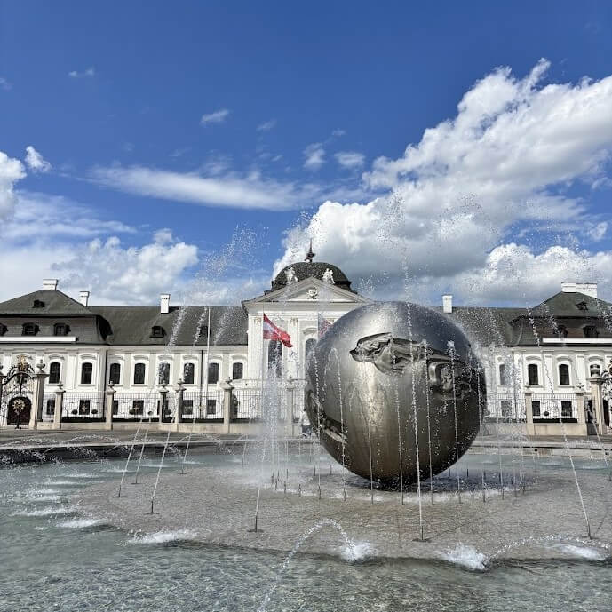 Palacio Grassalkovich con fuente y esfera de bronce, sede de la Presidencia de Eslovaquia, parada imprescindible en circuitos grupales por Bratislava