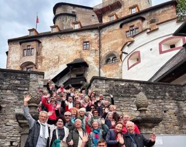 A group of tourists posing in front of Orava Castle with their guide Andy.