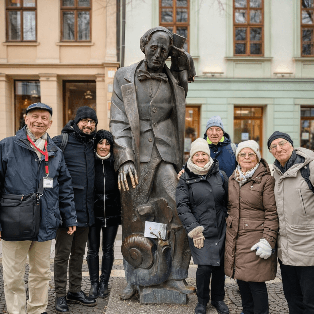 Small group tour in Slovakia – cultural sightseeing group posing next to a historic statue in a Slovak town, guided city tour by E-TRAVEL.SK DMC