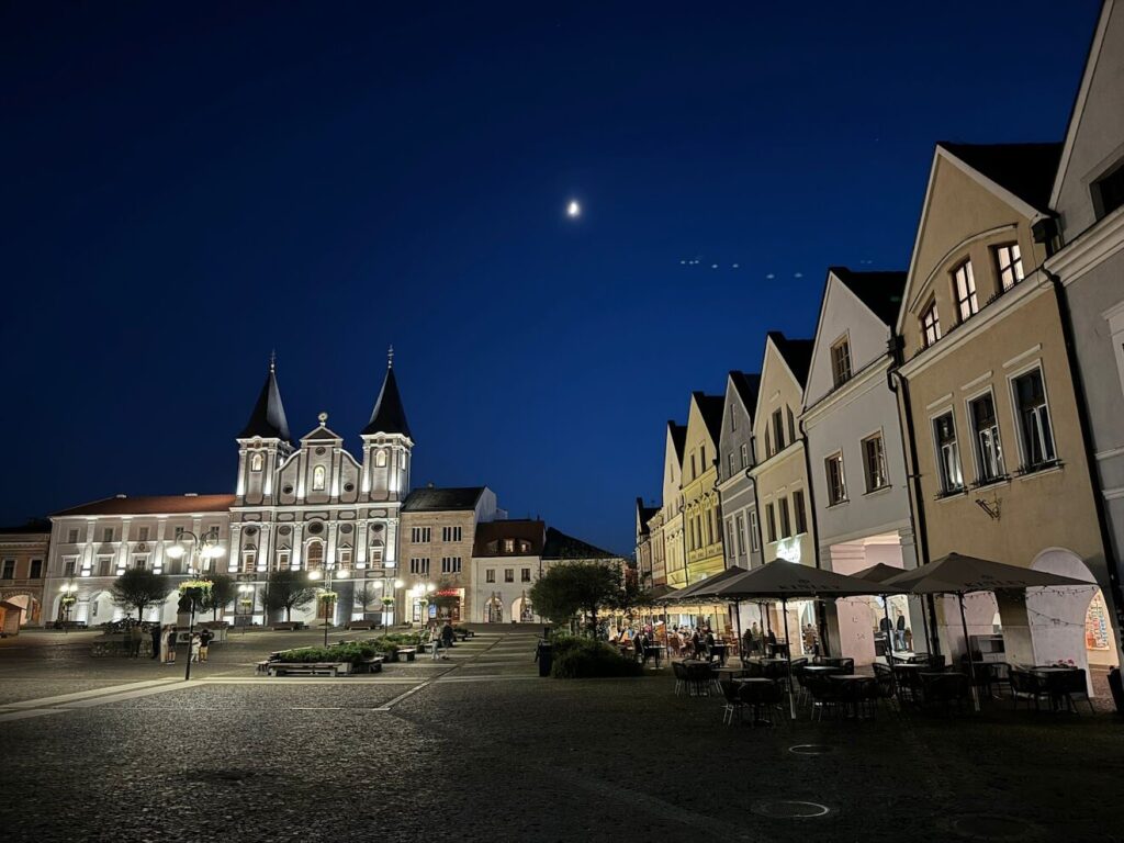 Night view of Žilina main square with church and cafes – things to do in Žilina